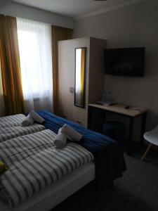 een slaapkamer met een bed, een bureau en een televisie bij Dom Przyjęć Pradziad in Rogów +7 foto's
