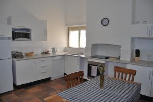 a kitchen with a table and chairs and a vase of flowers at Jacaranda Cottage in Murray Bridge