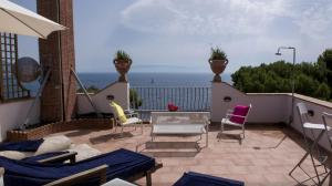 a patio with chairs and a table and the ocean at Villa Priscilla in Taormina