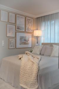um quarto com uma cama branca com fotografias na parede em Studio-Apartment Piccolino 26 em Timmendorfer Strand