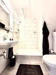 a bathroom with a tub and a sink and a shower at Das Stader Loft mit Sonnenbalkon in Stade