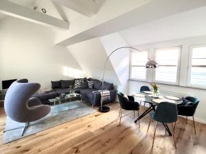 Una sala de estar con un sofá, una mesa y sillas. en Das Stader Loft mit Sonnenbalkon, en Stade
