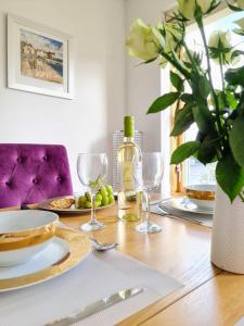 a table with a bottle of wine and wine glasses at New Holliday Villa, Anstruther in Cellardyke