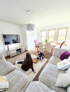 New Holliday Villa, Anstruther في Cellardyke: وجود امرأة وطفل يلعبون في غرفة المعيشة