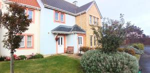 a white house with a porch and a yard at New Holliday Villa, Anstruther in Cellardyke