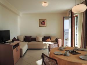 ein Wohnzimmer mit einem Sofa und einem Tisch in der Unterkunft Apartment BV 3785-1 in Baška Voda