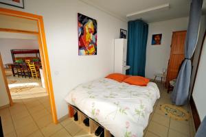 a bedroom with a bed with an orange pillow on it at Gîte le Rocher - Apartment on the ground floor for 8 people in La Grave