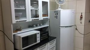 una cocina con microondas y nevera en Apartamento na Prainha, de um quarto!, en Arraial do Cabo