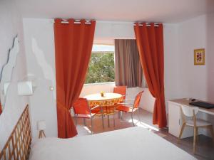 a room with a table and chairs and a window at Hôtel les Eucalyptus in Cavalaire-sur-Mer