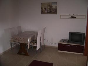 a room with a table and a table and a tv at Guesthouse Lopar (568) in Lopar