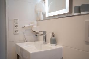 uma casa de banho com um lavatório branco e um espelho. em Studio-Apartment Piccolino 26 em Timmendorfer Strand