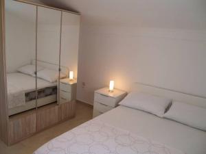 biała sypialnia z 2 łóżkami i 2 lustrami w obiekcie Apartment in Preko with Terrace, Air conditioning, WIFI, Washing machine (4568-2) w mieście Preko
