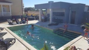 grupa ludzi bawiących się w basenie w obiekcie Room in Zaton (Zadar) with sea view, terrace, wireless, washing machine (4141-7) w mieście Zaton