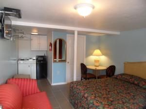 a bedroom with a bed and a table and a kitchen at Franklin Terrace Motel in Seaside Heights