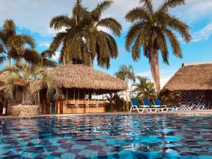 a resort swimming pool with palm trees and chairs at Punta Chame Club and Resort in Chame