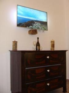 a dresser with a bottle of wine and a television on a wall at Studio apartment in Icici with Air condition, WIFI (4674-2) in Ičići