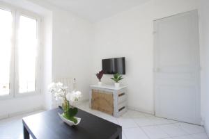 uma sala de estar branca com uma mesa e uma televisão em L'Arpajonais 4 Cosy Hyper Centre 5min N20 em Arpajon