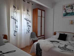 a bedroom with two beds and a window with writing on the wall at Hostal "Los Chanos el Ruso" in Galende