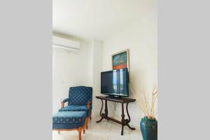 a living room with a tv and a chair at Peggy's lux apartment in Karavomylos