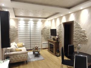 a living room with a couch and a television at Apartman S33 Vila Pekovic Green in Zlatibor