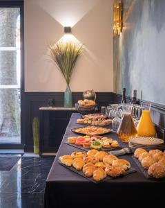 a table with a bunch of sandwiches and pastries at Hôtel Mijo's in Fontenay-sous-Bois