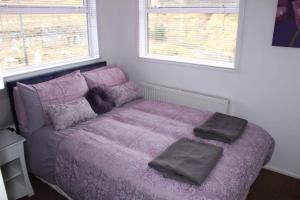 a bedroom with a purple bed with two pillows on it at Tigh na Freicadan in Spean Bridge