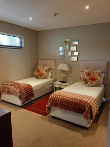 a bedroom with two beds and a mirror on the wall at Zimbali Suite 606 in Ballito