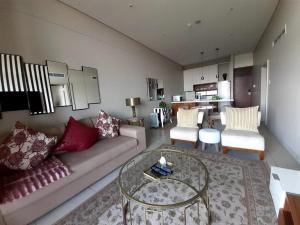 uma sala de estar com um sofá e uma mesa em Zimbali Suite 606 em Ballito