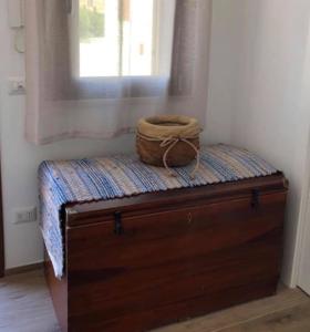 a bed with a basket sitting on top of it at Terrazza D'Amare in Favignana