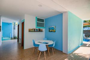 uma sala de jantar com paredes azuis e uma mesa e cadeiras em Casa Menta em Puerto Escondido