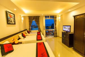 Habitación de hotel con 2 camas y TV en Moon's Homestay, en Hoi An