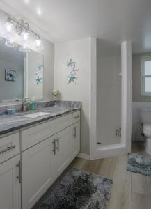 a white bathroom with a sink and a toilet at Waterfront & Pool B Star5Vacations in St. Pete Beach
