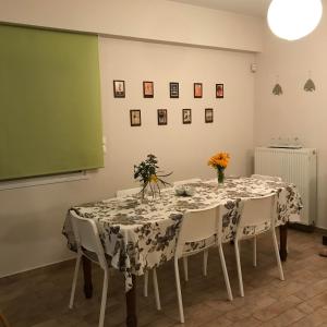 une salle à manger avec une table, des chaises et un écran vert dans l'établissement Sxinias Resort, à Marathon