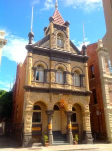a large brick building with a clock on the front of it at Fremantle Bed & Breakfast in Fremantle