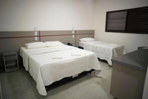 a room with two beds with white sheets at Villa Vaz Hotel in Rondonópolis +28 photos