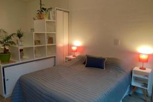 um quarto com uma cama e duas lâmpadas em duas mesas em Utopia´s house. em Buenos Aires
