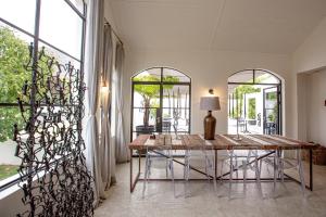a dining room with a table and some windows at Franschhoek Maison du Cap in Franschhoek