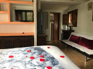 Un dormitorio con una cama con rosas rojas. en Cabaña en la naturaleza, en Collado-Villalba
