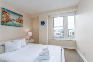a white bedroom with a large white bed and a window at Heaven on Washington Fully Furnished Apartments in Washington +34 photos