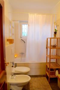 baño con aseo y lavabo y ventana en Namasté - Ayurveda & Benessere en Lugano