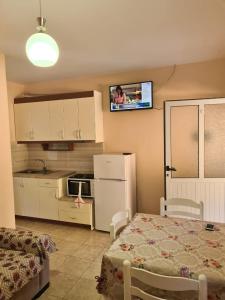 a kitchen with a refrigerator and a tv on the wall at Martini Vacation Home in Sarandë