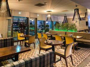 a restaurant with wooden tables and yellow chairs at Ostimpark Business Hotel in Ankara