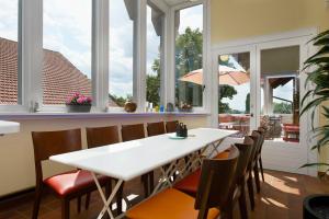 jadalnia z białym stołem i krzesłami oraz oknami w obiekcie LindenGut Biohotel w mieście Dipperz