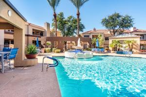 a swimming pool with a fountain in the middle at Sahuaro Condos in Scottsdale