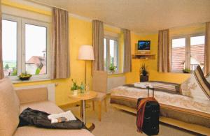 een hotelkamer met 2 bedden en een bank bij Gasthaus Zum güldenen Rößlein in Homburg