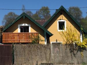 a yellow house with a porch and a fence at Book-A-Room Salzburg Garden or Balcony Stay - 2 bedroom - air conditioning & free parking in Salzburg