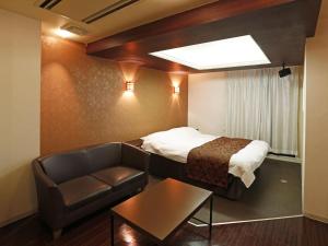 a hotel room with a bed and a couch at Hotel Fine Garden Gifu in Kakamigahara