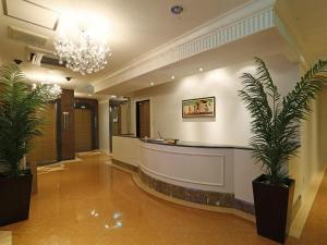 a hotel lobby with a reception desk and plants at Hotel Fine Garden Gifu in Kakamigahara