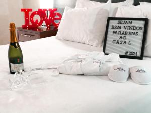 Mercure Sao Paulo Grand Plaza Paulista في ساو باولو: سرير أبيض مع زجاجة من الشمبانيا والمناشف