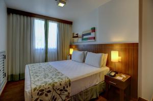 a hotel room with a bed and a window at Nobile Suites Monumental in Brasília